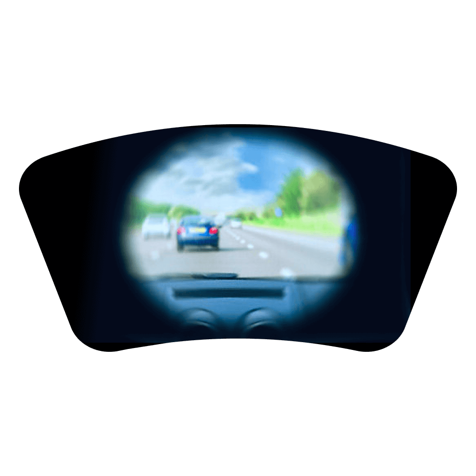 A blurred view of the highway leading home through a vehicle's rearview mirror.